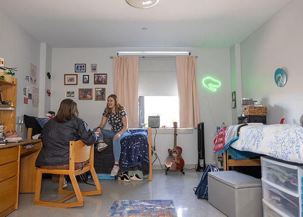 students hanging out in their room in Hawk Hall